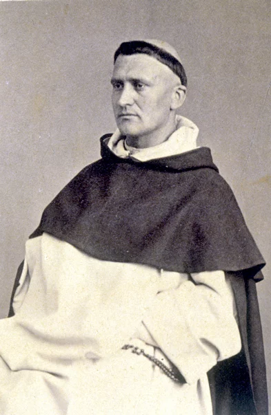 Portrait ancien en noir et blanc d'un moine avec tonsure, vêtu d'un habit monastique blanc et noir, tenant un chapelet. Photo historique d'un religieux catholique.